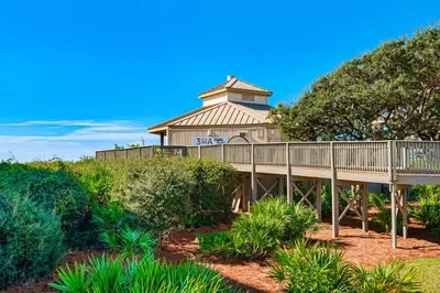 a large house with a tower on top of a hill at Beachfront condo with 2 beach chairs included & pickleball - short walk to dining in Seacrest