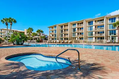 a swimming pool in front of a apartment building at Coastal condo with lagoon pool bike rentals tennis pickleball & beach access in Seacrest