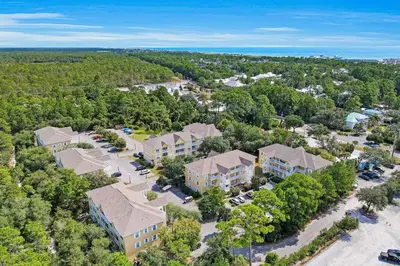 an aerial view of a house with a parking lot at Pool-view condo with private balcony washer and dryer Wifi in Santa Rosa Beach
