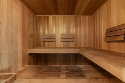 a sauna with wooden walls and two chairs in it at Lovely condo with pool hot tub ocean views & pickleball in Santa Rosa Beach