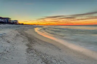 a view of a beach with a sunset in the background at Water-view condo with pool hot tub & pickleball in Rosemary Beach