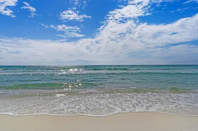 a beach with the ocean and a cloudy sky at Luxe Beachfront Resort Condo with Private Beach Access & Top Amenities in Santa Rosa Beach