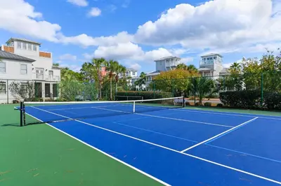 a tennis court in front of some houses at Dunes of Seagrove condo with pool hot tub sauna gym & tennis pickleball in Santa Rosa Beach