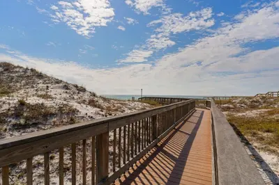 a boardwalk to the beach on a sunny day at Dunes of Seagrove condo with pool hot tub sauna gym & tennis pickleball in Santa Rosa Beach