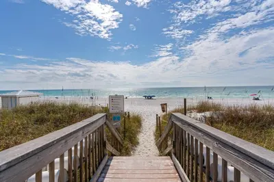 a boardwalk leading to the beach with the ocean at Dunes of Seagrove condo with pool hot tub sauna gym & tennis pickleball in Santa Rosa Beach
