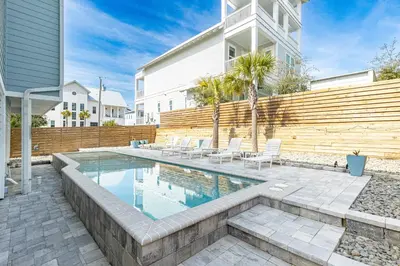 a swimming pool in the backyard of a house at New Kululu EAST - 3 BR Short walk to the beach, heated pool, Sleeps 12 in Santa Rosa Beach
