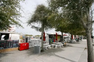 a sidewalk with tables and trees and a food truck at Blue Sky Bungalow 156 in Seagrove Beach