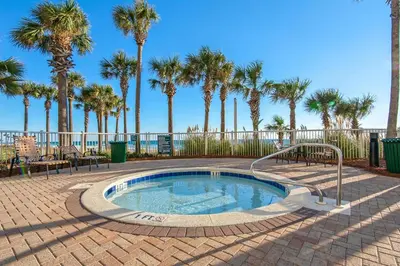 a small swimming pool with palm trees in the background at Grand Panama 1-303 in Panama City Beach