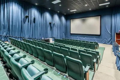 an empty auditorium with green chairs and a screen at Majestic Beach Towers 2-2003 in Panama City Beach