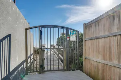a gate to a driveway with a wooden fence at Magnolia Cottages by the Sea by Panhandle Getaways in Watersound Beach
