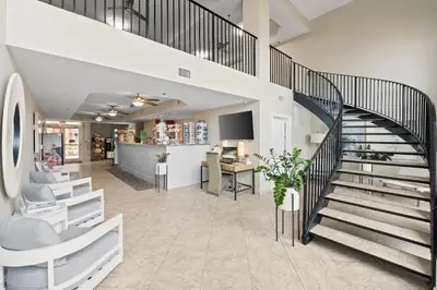 a staircase leading up to a lobby with a desk at Calypso Beach Resort Towers in Panama City Beach