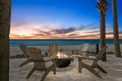 three chairs and a fire pit on the beach at Calypso Beach Resort Towers in Panama City Beach