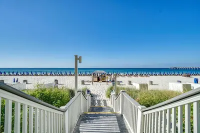 a stairway leading down to a beach with the ocean at Calypso Beach Resort Towers in Panama City Beach