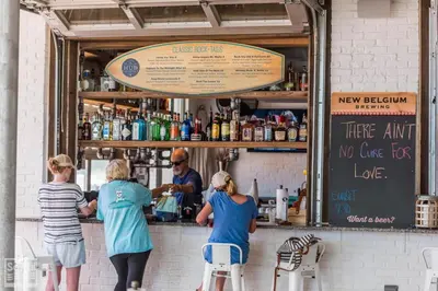 a group of people standing at the counter of a bar at Prominence on 30A Vacation Homes in Watersound Beach
