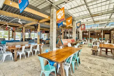 an empty restaurant with wooden tables and chairs at Prominence on 30A by Panhandle Getaways in Watersound Beach