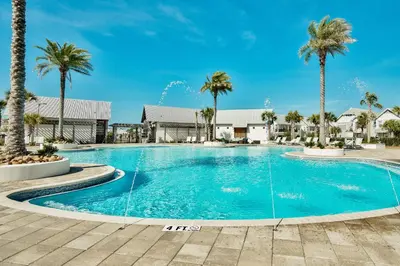 a swimming pool with palm trees in a resort at Prominence on 30A by Panhandle Getaways in Watersound Beach