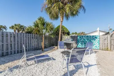 a group of chairs and a table and a fence at Villa Paradise, Pet Friendly in Panama City Beach