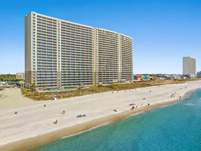 a large building on a beach next to the ocean at Emerald Beach in Panama City Beach