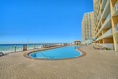 a swimming pool in front of a building next to the beach at Treasure Island 0211 in Panama City Beach
