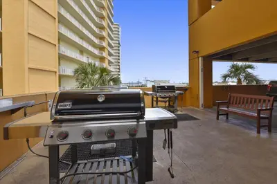 a grill on an outdoor patio with a building at Treasure Island 0503 in Panama City Beach