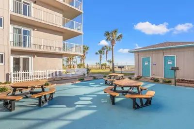 a group of picnic tables and benches in front of a building at The Summit 1217 in Panama City Beach