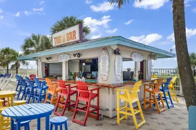 a bar with colorful chairs and tables at the beach at The Summit 616 in Panama City Beach