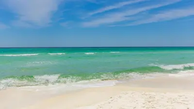 a sandy beach with the ocean in the background at Inn to the Mystic in Santa Rosa Beach