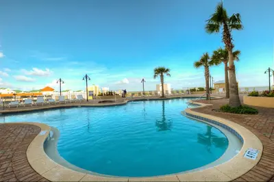 a large swimming pool with palm trees in a resort at Laketown Wharf 734 By Aneliya in Panama City Beach