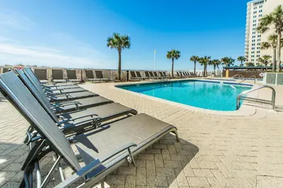 a row of lounge chairs next to a swimming pool at Ocean Villa 1406 in Panama City Beach