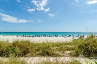 a beach with a lot of chairs and the ocean at Sunbird 0208W 'Surfside Sandcastle' in Panama City Beach