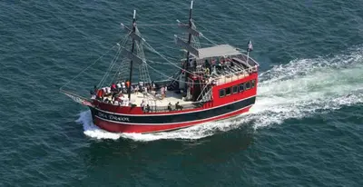 a red boat with people on it in the water at Boardwalk 2111 'Seaside Memories' in Panama City Beach