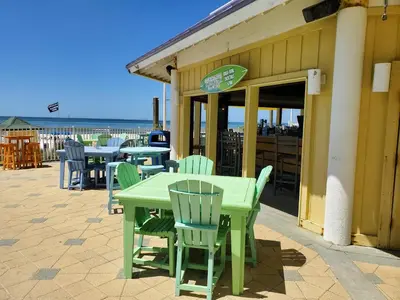 a green table and chairs sitting outside of a restaurant at Boardwalk 2111 'Seaside Memories' in Panama City Beach