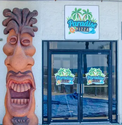 a front door of a restaurant with a statue of a face at Edgewater 3-0810 'Alpaca My Bags' in Panama City Beach