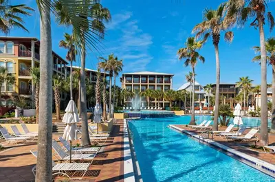 a pool at the resort with lounge chairs and palm trees at Daze Gone Bye in Panama City Beach