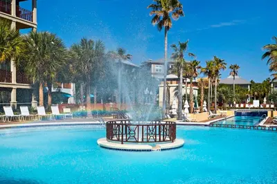 a fountain in the middle of a pool with palm trees at Daze Gone Bye in Panama City Beach