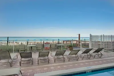 a row of chairs and tables next to a pool at Marisol 501 in Panama City Beach