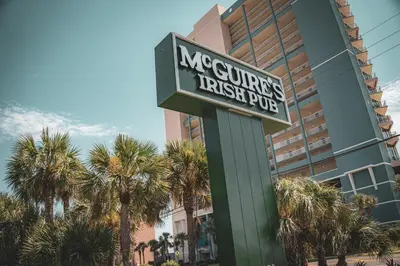 a sign in front of a hotel with palm trees at Boardwalk 805 in Panama City Beach