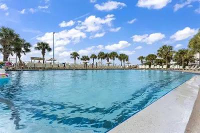 a large swimming pool with palm trees in the background at The Summit 1006 in Panama City Beach