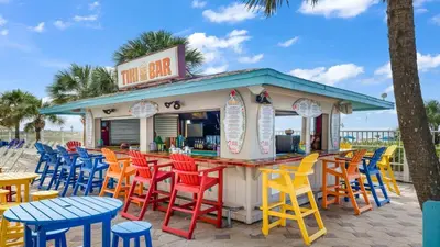a bar with colorful chairs and tables on the beach at The Summit 624 in Panama City Beach