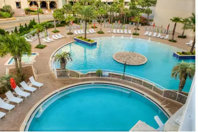 an overhead view of a large swimming pool with white chairs at BRAND NEW!Laketown Wharf 233! Beautiful 3 BD, Great Amenities, And Great Location in Panama City Beach