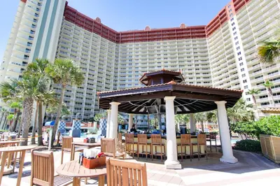 a gazebo with tables and chairs in front of a resort at Shores of Panama #612 by Book That Condo in Panama City Beach