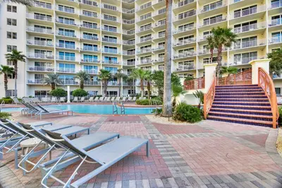 a swimming pool with lounge chairs and a building at Shores of Panama #1217 by Book That Condo in Panama City Beach
