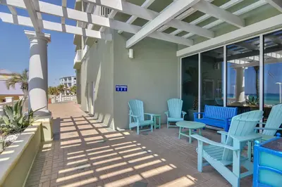a patio with blue chairs and tables on a building at Boardwalk Beach Resort #1802 by Book That Condo in Panama City Beach