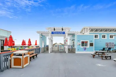 a large deck with benches and a blue building at Commodore Resort #703 by Book That Condo in Panama City Beach