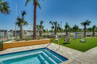 a swimming pool with palm trees in a park at Calypso Tower 3 Beach Resort in Panama City Beach