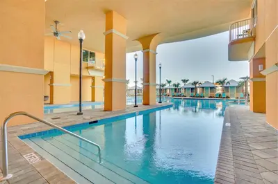 a swimming pool at a resort with blue water at Calypso Tower 3 Beach Resort in Panama City Beach