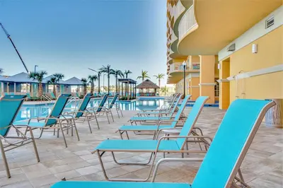 a row of chairs sitting next to a swimming pool at Calypso Tower 3 Beach Resort in Panama City Beach