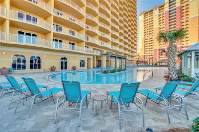 a hotel patio with chairs and a swimming pool at Calypso Tower 3 Beach Resort in Panama City Beach