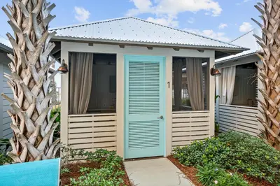 a small house with a blue door and trees at Tower 3 at Calypso Beach Resort in Panama City Beach