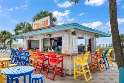 a bar with colorful chairs and tables on the beach at The Summit 1408 in Panama City Beach